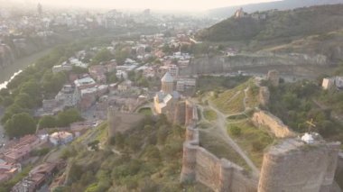 Narikala kalesindeki Aziz Niklas Kilisesi 'ne hava manzarası ve gün doğumunda Tiflis' in güzel panoramik manzarası. Gürcistan, Doğu Avrupa