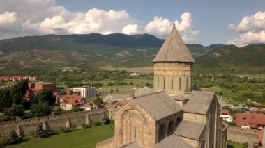 Gürcistan 'ın Tiflis kenti yakınlarındaki ünlü Svetitskhoveli Ortodoks Katedrali ve tarihi ve turistik kent Mtskheta' ya hava manzarası. Arka plandaki dağlarda ve Aragvi nehrinde