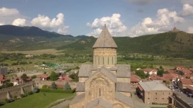 Gürcistan 'ın Tiflis kenti yakınlarındaki ünlü Svetitskhoveli Ortodoks Katedrali ve tarihi ve turistik kent Mtskheta' ya hava manzarası. Arka plandaki dağlarda ve Aragvi nehrinde