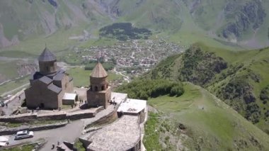 Gergeti Trinity Kilisesi ya da Tsminda Sameba, Holy Trinity Kilisesi Georgia, Mount Kazbegi, Gürcistan altında Gergeti köyü yakınındaki havadan görünümü