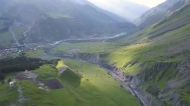 Drone havadan görünümden uçurumu ve kırık dağ Kazbegi, köy Stepantsminda Gürcistan yakınındaki dağlara