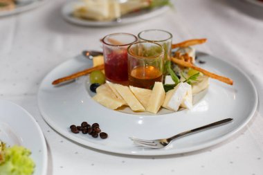 Brie peyniri, parmesan, üzüm, kuş üzümü ve şenlikli masaya soslar ile plaka