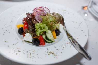 Masanın üzerinde beyaz bir plaka üzerinde taze Yunan salatası