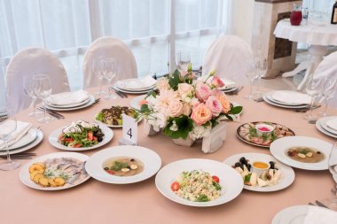 Ziyafet Restoran tablosunu için yemekler ile servis, snack, çatal bıçak takımı, şarap ve su bardağı.