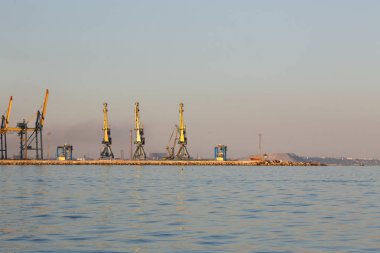 Birçok büyük vinçler siluet günbatımı Altın ışık, Azak Denizi bağlantı noktası olarak. Mariupol, Donetsk region, Ukrayna