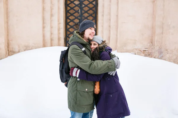 楽しんで冬雪に覆われた街で幸せな若いカップル — ストック写真