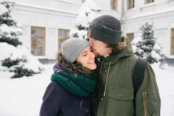 楽しんで冬雪に覆われた街で幸せな若いカップル — ストック写真
