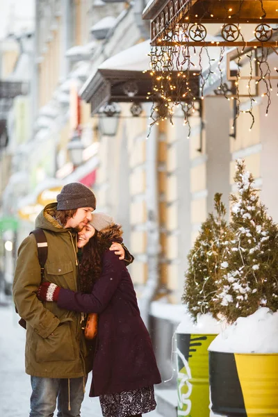 若いカップル 降雪下で路上でキスや夜の街の灯 — ストック写真