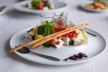 Brie peyniri, parmesan, üzüm, kuş üzümü ve şenlikli masaya soslar ile plaka