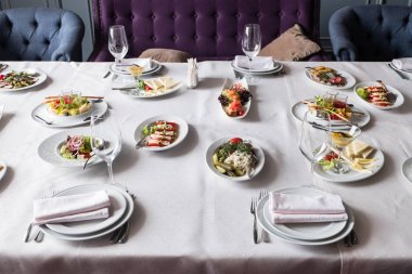Ziyafet Restoran tablosunu için yemekler ile servis, snack, çatal bıçak takımı, şarap ve su bardağı.