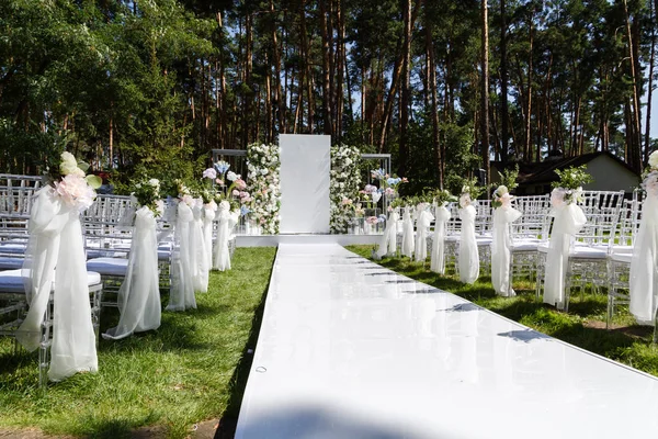 白色的人行道通向一个装饰着鲜花的婚礼拱门 — 图库照片