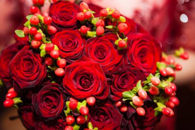 Gelin kırmızı dantel elbise yuvarlak bir buket kırmızı gül tutuyor