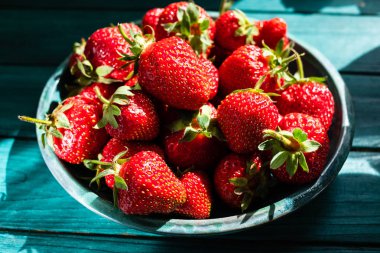 Yeşil plaka üzerinde yeşil ahşap masa güzel fişek ve gölge ile taze çilek