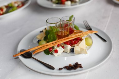 Brie peyniri, parmesan, üzüm, kuş üzümü ve şenlikli masaya soslar ile plaka