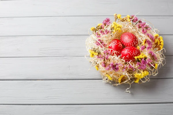 Hand painted red easter eggs on wooden table — Stock Photo, Image