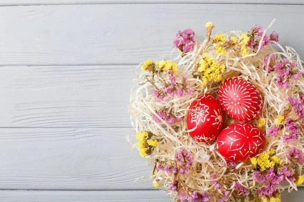 Hand painted red easter eggs on wooden table — Stock Photo, Image