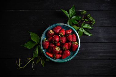 Siyah arka plan karşı bir plaka üzerinde taze çilek