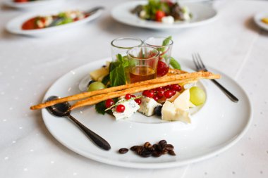 Tabak brie, parmesan, üzüm, kuş üzümü ve soslar