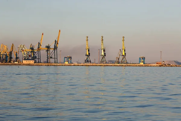 Muchas grandes grúas silueta en el puerto marítimo de Azov a la luz dorada de la puesta del sol. Mariupol — Foto de Stock