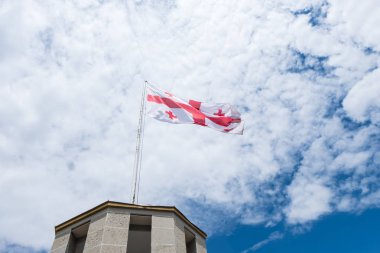 Mavi gökyüzü ve bulutlar ile Gürcistan bayrağı