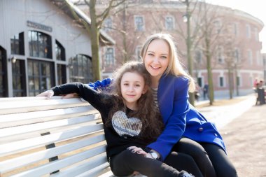  Güzel anne ile kızı parkta bankta.