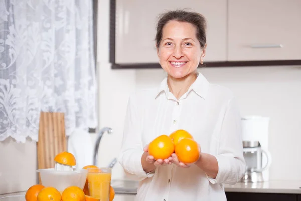 Усміхнена Жінка Середнього Віку Готує Апельсиновий Сік Кухні — стокове фото