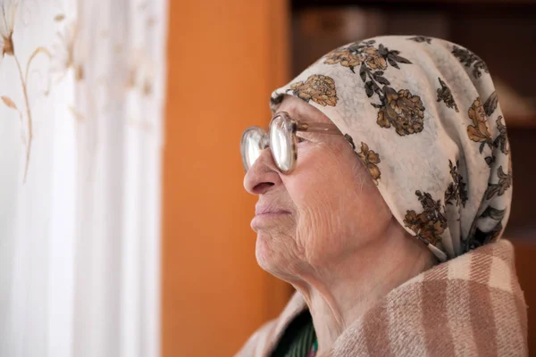 elderly woman in   scarf and  glasses   at home.