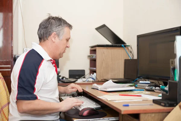 Busy man at  computer in  cabinet at home