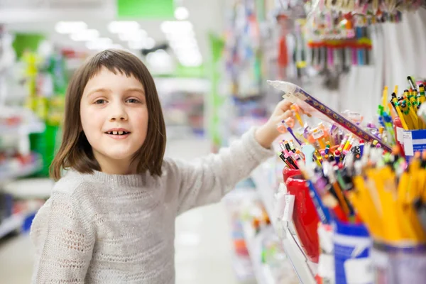 first grader buying pens and pencils in   bookstor