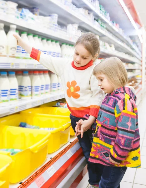 two girls 4 and 6 years old at   grocery store.