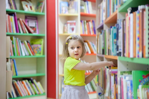 preschooler  choosing books at   library.