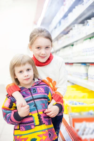 two girls 4 and 6 years old at   grocery store.