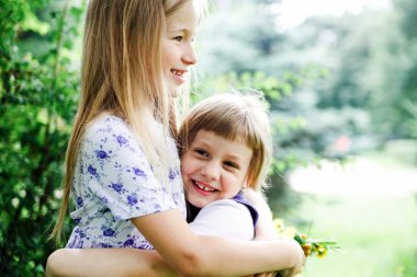  Yaz aylarında sokakta kucaklayan iki kız kardeş.