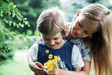  Yaz aylarında sokakta kucaklayan iki kız kardeş.