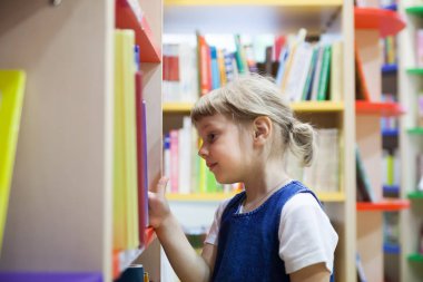  kitaplığındaki kitap seçme güzel kız. 