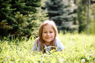  8 yıllık kız çimlerin üzerinde parkta yürüyor.. 