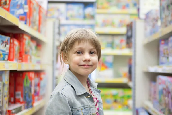 Little girl in   toy store looking  toys
