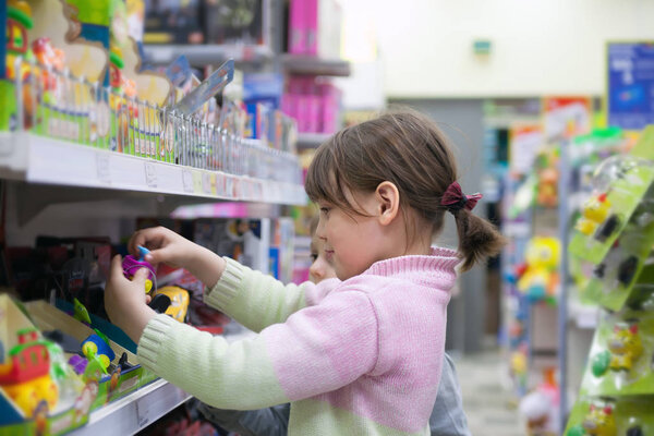  Little girls choosing what to buy in   toy store