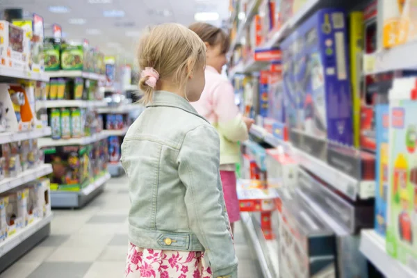 Little girls choosing what to buy in   toy store