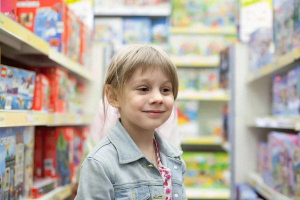 Little girl in   toy store looking  toys