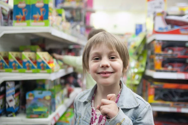 Little girl in   toy store choosing   toys