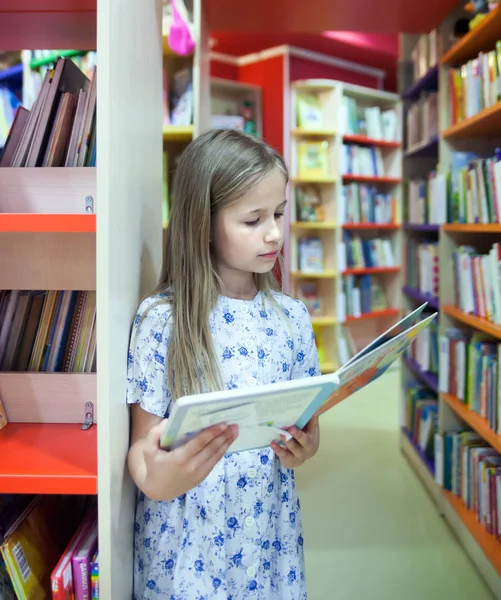 学校图书馆里的女孩阅读本书 — 图库照片
