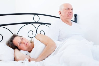 yatakta hayal kırıklığına uğramış adamın yanında rahatsız kadın.