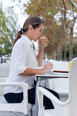 Beyaz ile kafeterya masada kahve içme kadın. 