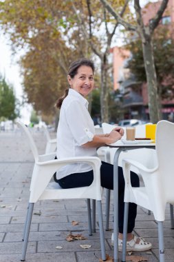 Beyaz ile kafeterya masada kahve içme kadın. 
