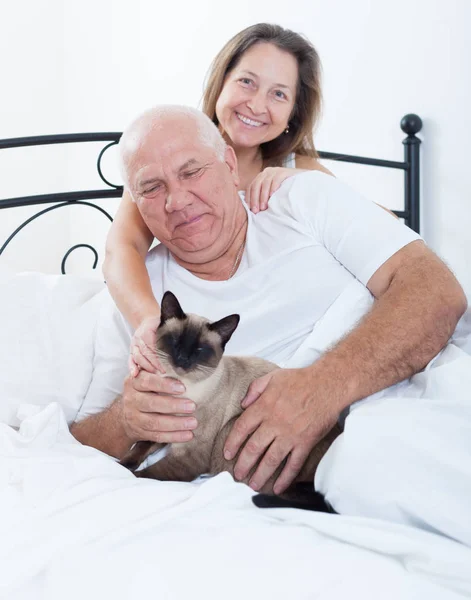 Mature man and woman on   bed in   bedroom.