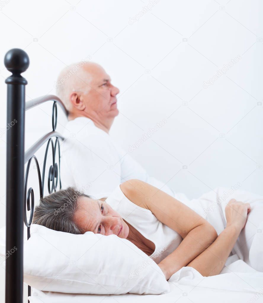 Adult man arguing with   woman sitting in bed.