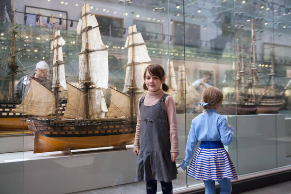 Girl of 7 years studying   exhibits in   museum.