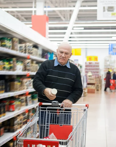 elderly man with   trolley in   supermarket between