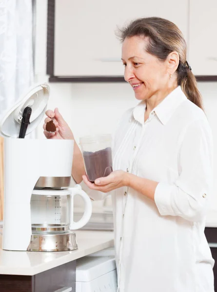 Smiling woman in   kitchen  near  coffee machine.